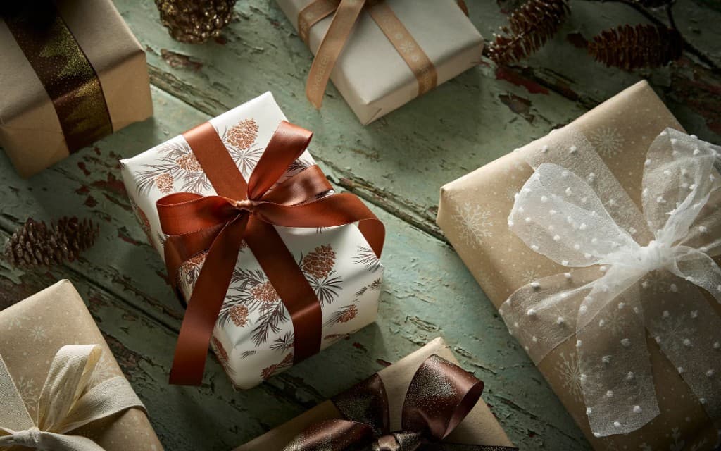 Wrapped gift boxes with ribbons and pinecones